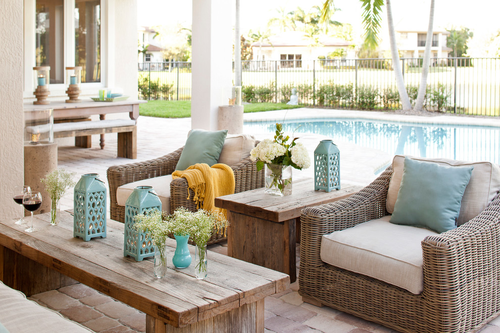 a small rustic patio with wicker ad wooden furniture and aqua touches by the pool  (Krista + Home)