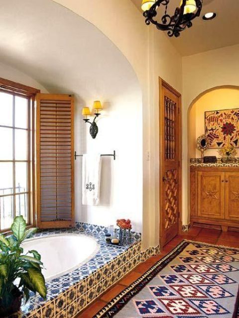 a bathroom with a Moroccan rug and blue and white tiles and shutters on the window