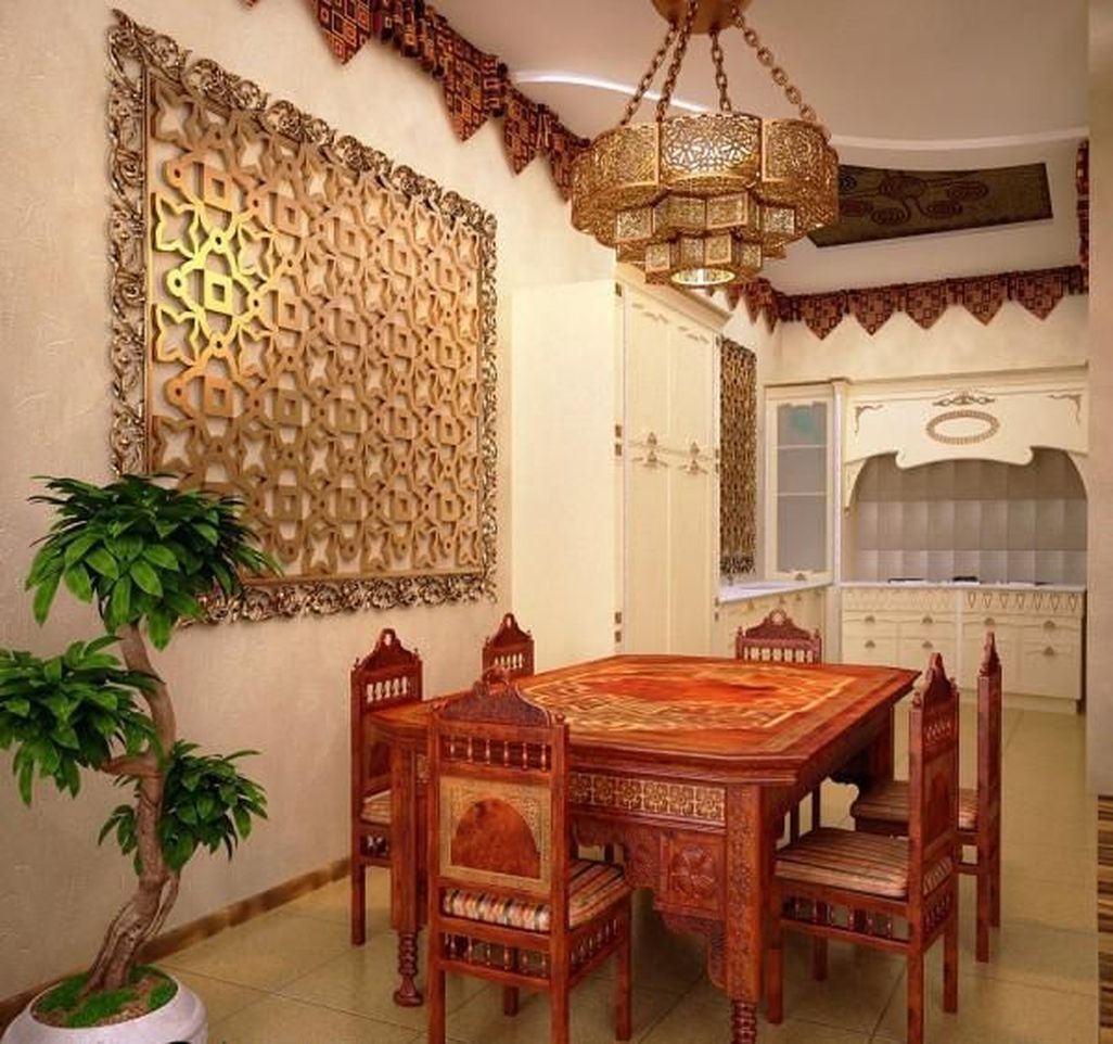 a beautiful dining room with heavy carved Moroccan furniture, a beautiful metal pendant lamp and a laser cut artwork