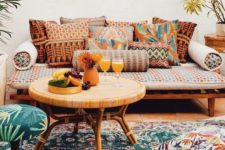 a boho patio with rattan and wooden furniture, printed pillows and rugs plus cushions and ottomans