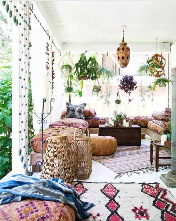 a bright boho patio with wooden and metal lanterns, rattan lamps on the floor, colorful and printed textiles, rugs and pillows