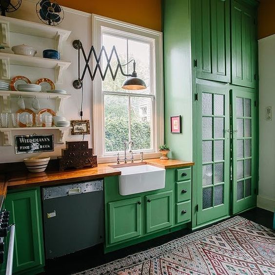 a bright green kitchen withwooden countertops and a colorful printed rug feels vintage