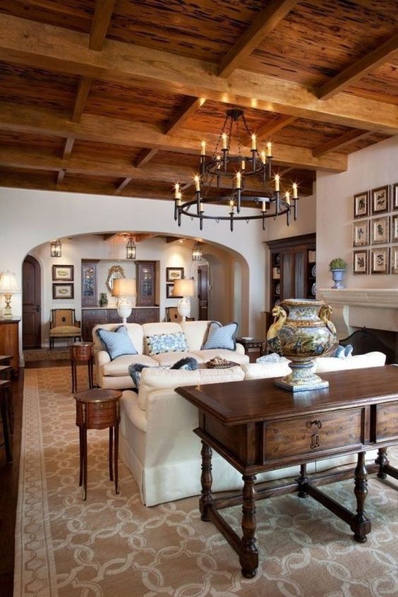 a chic and cozy rustic living room with rich stained furniture, a wooden ceiling and neutral sofas plus a fireplace