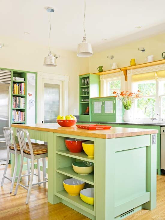 a chic farmhouse mint kitchen with light yellow walls, mint green cabinets, wood and stone countertops and yellow touches