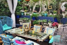 a colorful boho patio with rattan chairs in various colors, colorful pillows, bright glass lanterns and a simple table