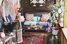 a colorful boho patio with wicker and wooden furniture, folksy artworks, lights, fringe, macrame and boho rugs