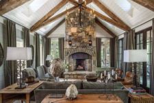 a cottage living room with a stone clad fireplace, wooden beams, wooden furniture and baskets