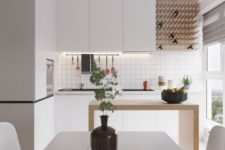 a minimalist white kitchen with built-in lights, a wine bottle rack, a minimal wooden kitchen island and a white dining set