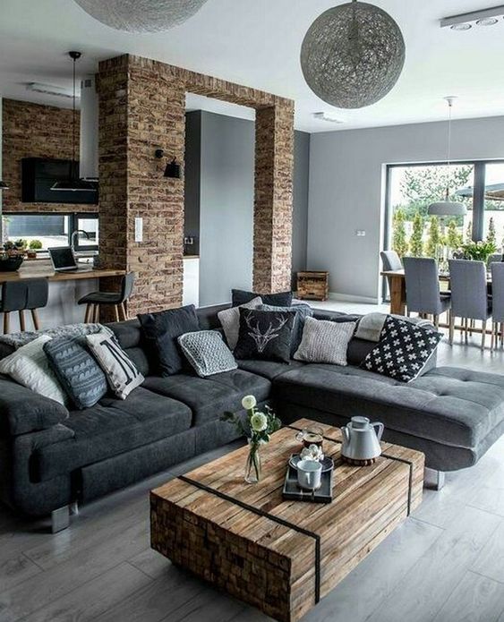 a modern rustic living room with a wood slab table and brick walls and a brick arch is veyr stylish