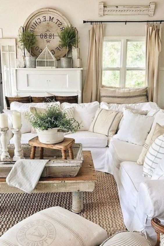 a neutral rustic living room with wooden tables, whitewashed wood elements and white and neutral furniture for a farmhouse feel