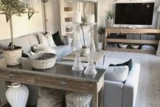 a neutral rustic living space with a wooden console, TV unit and a coffee table plus some baskets for storage