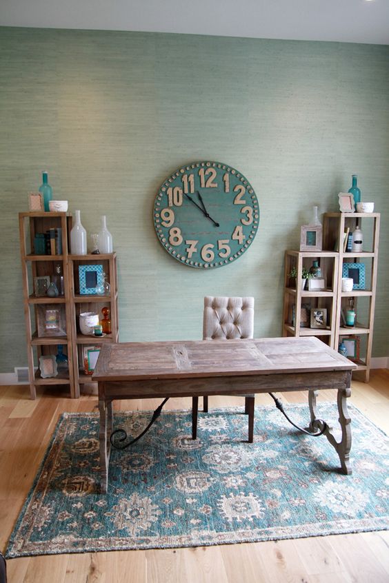 a rustic home office with a wooden desk and shelves, a clock, a bold rug and some decor
