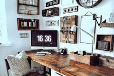 a rustic vintage home office with a shared desk, some art on the wall, wooden chairs and lots of rustic decor