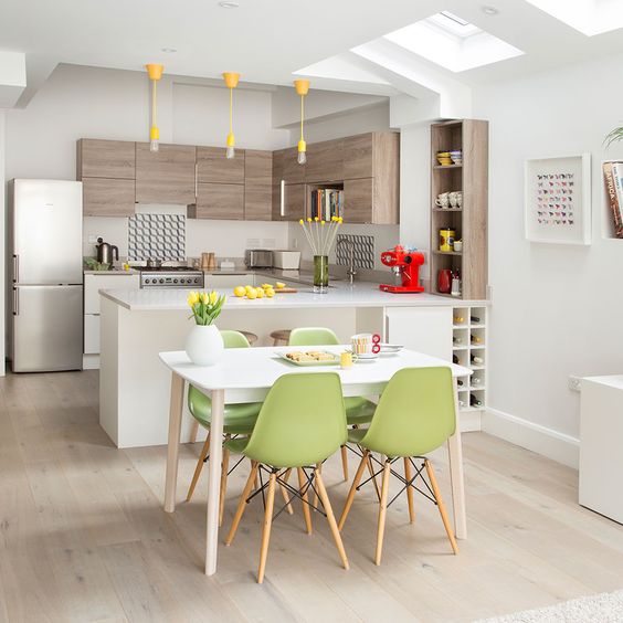 a stylish contemporary kitchen with wooden and white cbainets, with yellow bulbs, green chairs and some yellow touches