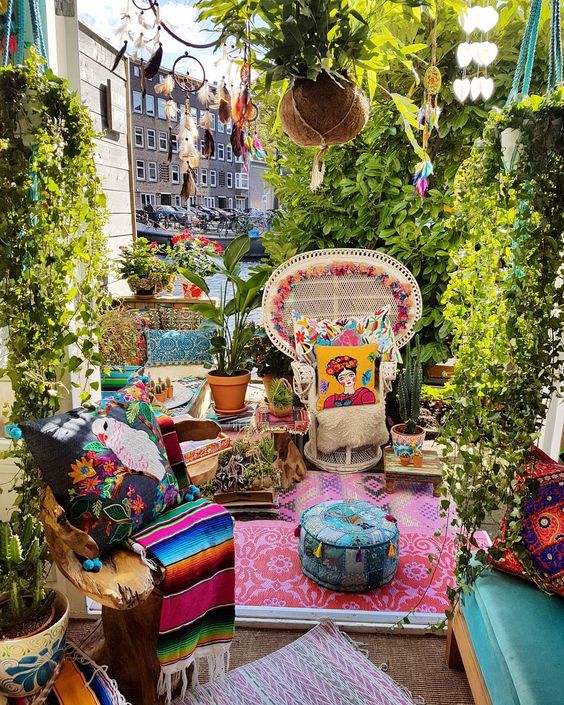 a super colorful boho patio with bright pillows, rugs, blankets, dream catchers and printed rugs
