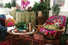 a very bright living room with colorful rugs, cushions and pillows, baskets on the wall and painted furniture