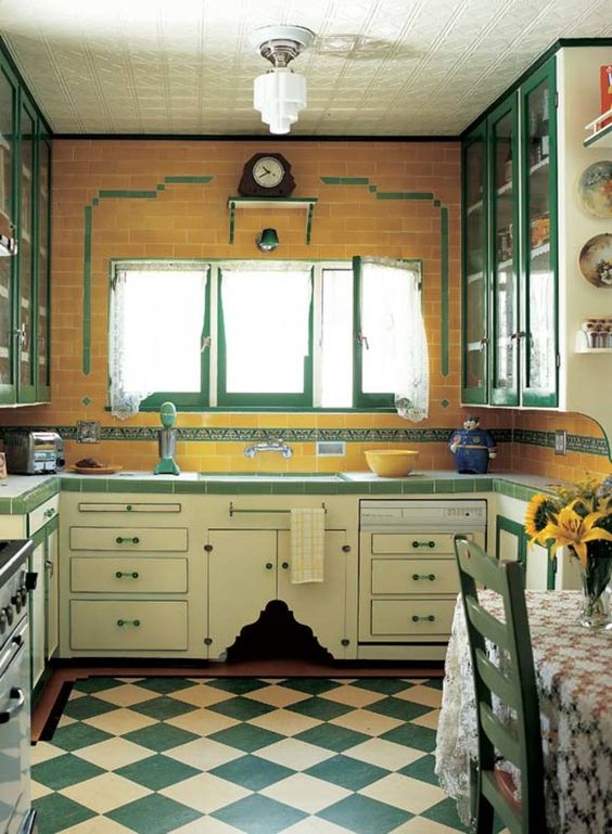 a vintage kitchen with a yellow subway tile wall, neutral and emerald kitchen cabinets and a checked kitchen floor