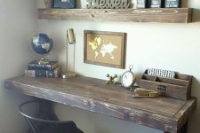 a vintage rustic home office with open shelves, a dark stained desk, a black chair and some decor