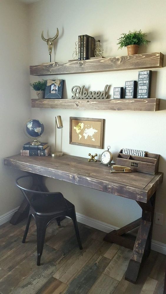 a vintage rustic home office with open shelves, a dark stained desk, a black chair and some decor