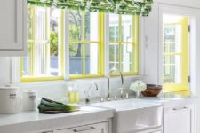 a white cottage kitchen with a yellow frame window and a botanical print curtain plus a yellow door