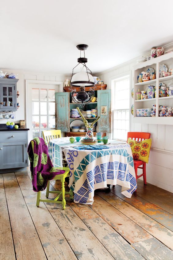 blue cabinets, a turquoise sideboard and colorful chairs, textiles and porcelain