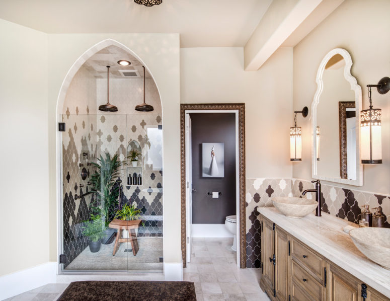 a Moroccan master bathroom includes a hand-carved wood vanity made in Morocco and black and white Moroccan tiles arranged in a catchy way  (Harjo Construction)