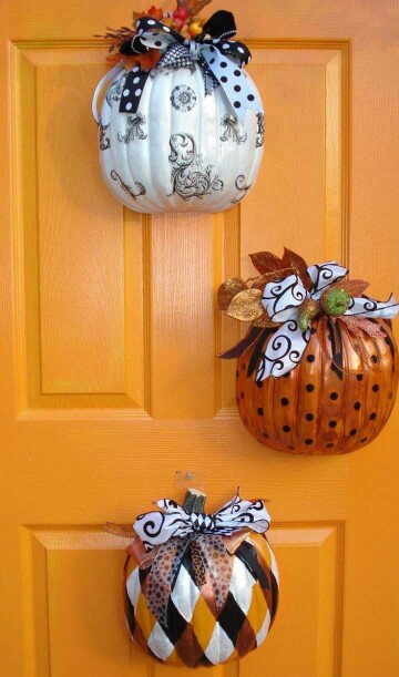 Dollar store pumpkins could be decorated and hanged on a door.