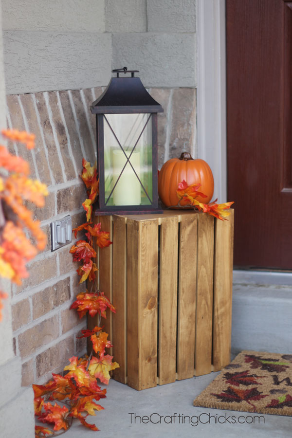 For a small porch you won't need more than a single wood crate, one lantern, a pumpkin and a faux leaves garland.