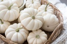a basket tray with white pumpkins is a cool and cozy fall decoration or a centerpiece in neutral shades