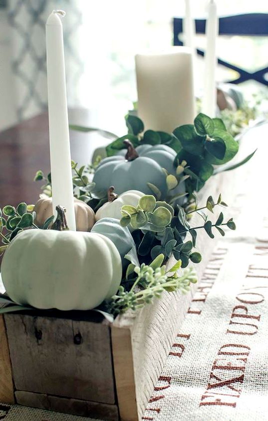 a beautiful pallet box fall centerpiece filled with chalk painted pumpkins, greenery and candles is stylish