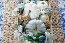 a bread bowl with neutral and pastel pumpkins, blue blooms, bleached pinecones and pale and usual foliage for the fall