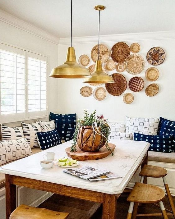 a bright boho dining space with an arrangement of decorative plates, pendant lamps, colorful printed pillows