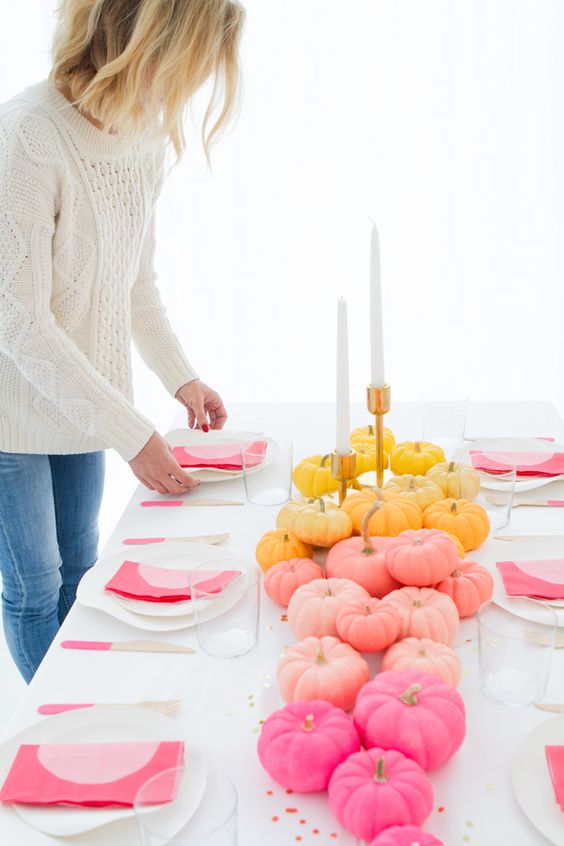 a bright modern pumpkin centerpiece with an ombre effect and tall candles for a modern fall tablescape