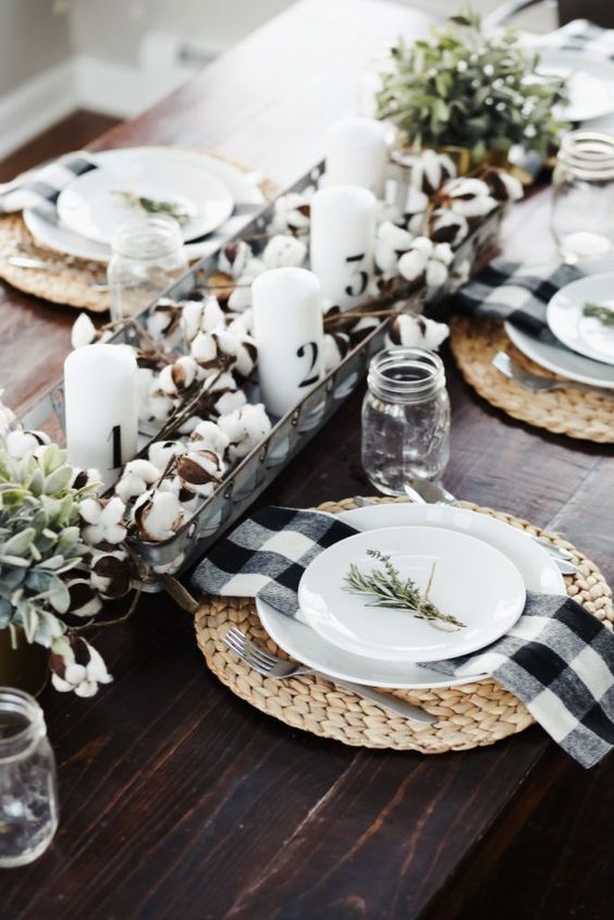 a cool fall centerpiece of cotton, greenery and candles, woven placemats and plaid napkins