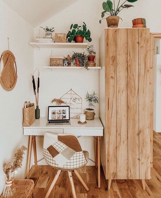 a cozy neutral boho home office nook with a desk, a patchwork chair, a catchy hanging and open shelves plus a storage piece