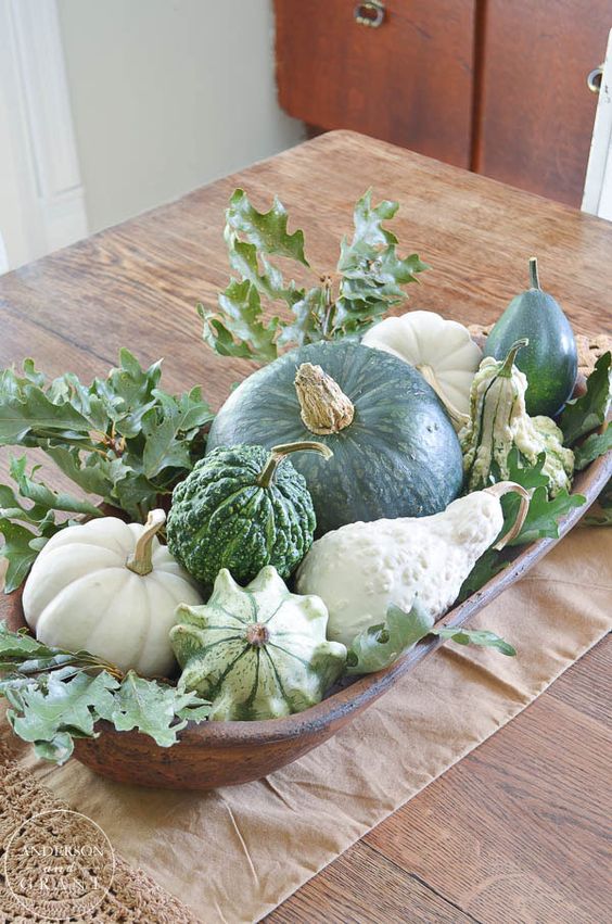 a dough bowl with pumpkins and gourds and foliage is a cool fall all-neutral centerpiece