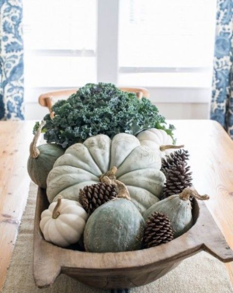 a dough bowl with pumpkins and gourds, pinecones and cabbage is a rustic and relaxed centerpiece for the fall