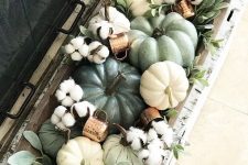 a dough bowl with pumpkins, real and faux ones, cotton, greenery and copper mugs is a chic and stylish arrangement to decorate a space