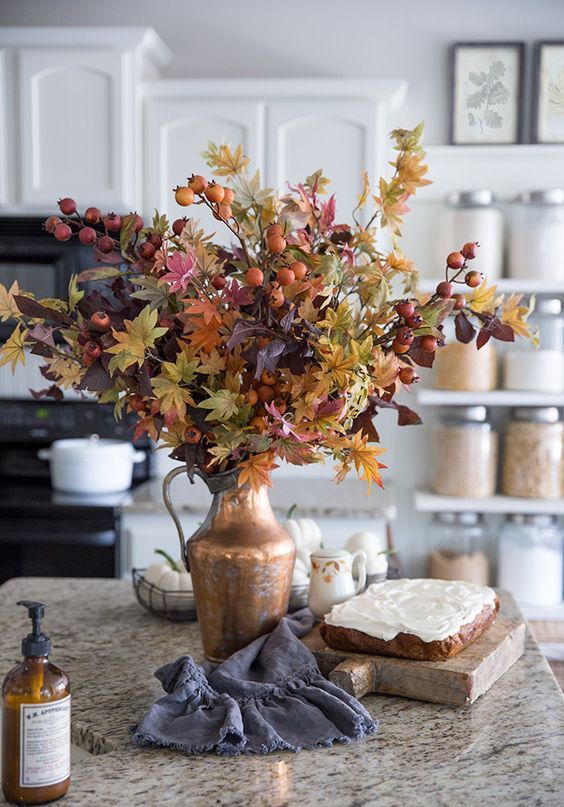 a fantastic and bright fall leaf and berry attangement in a metallic vase is an amazing idea