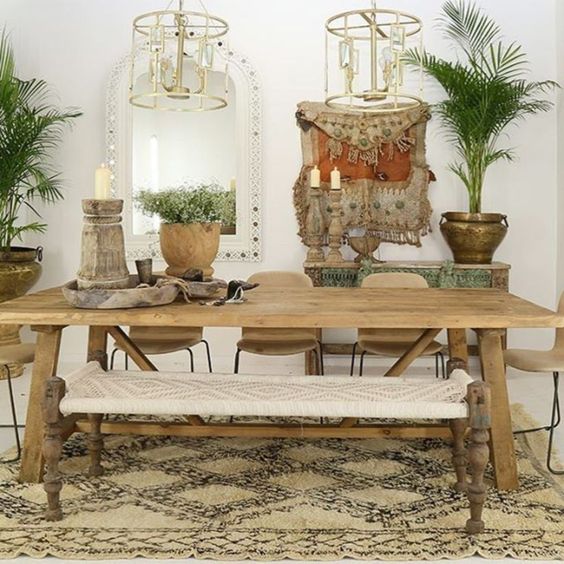 A free spirited dining room with catchy pendant lamps, carved wooden furniture and a macrame bench