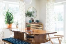 a mid-century modern meets boho dining space with a live edge table, a hairpin ottoman, potted greenery