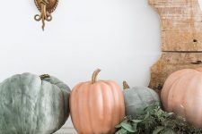 a natural fall mantel with lots of pumpkins and eucalyptus is a pretty decoration for the fall