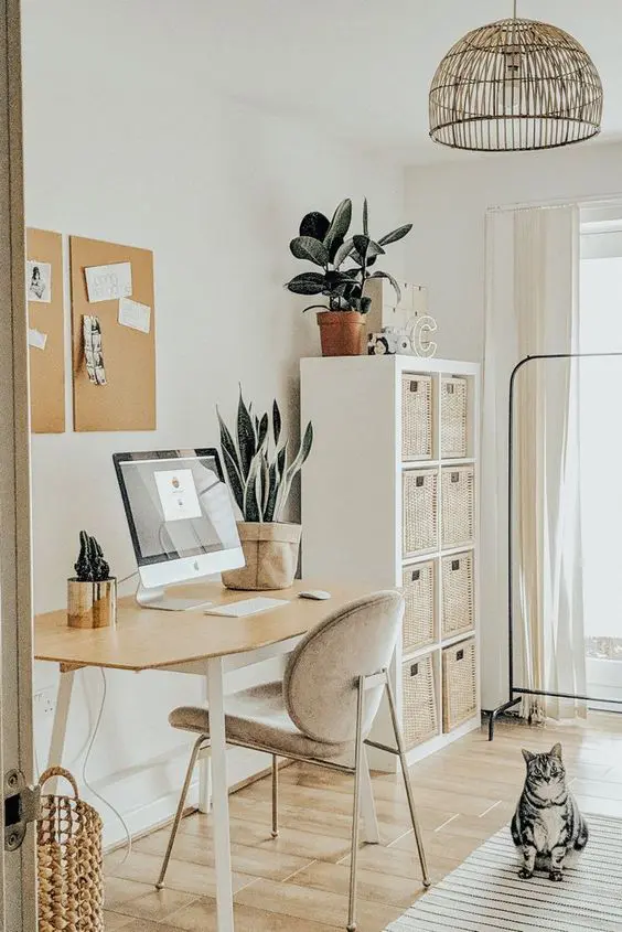 a neutral boho space with a desk, a comffy chair, a storage unit with baskets, a basket, memo boards and a a rattan chandelier