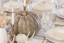 a neutral fall table with natural pumpkins, antlers, tall candles, wheat in jugs, white porcelain and a plaid table runner