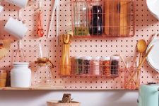 a pink pegboard hanging over the cabinets allows attaching a lot of shelves, hooks and wire holders