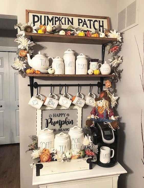 a pumpkin patch with fake flowers and leaves, a sign, a hay doll and some neutral porcelain jars