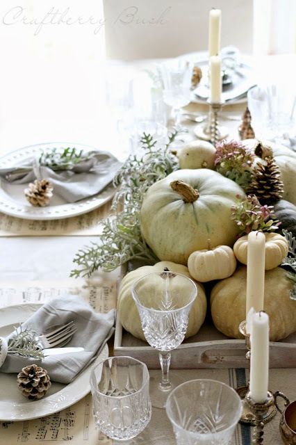 a tray with neutral pumpkins, pale greenery and pinecones plus candles for a rustic fall centerpiece