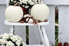 a white vintage chair with white potted blooms, white pumpkins and nuts and acorns feels very natural