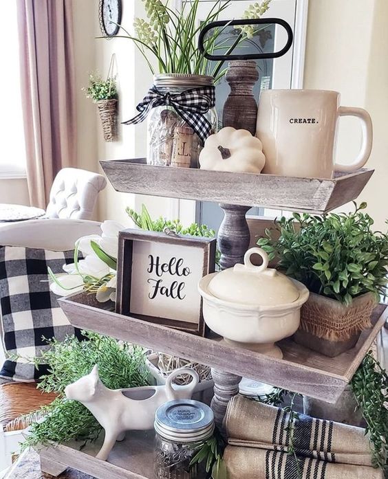 a wooden fall stand with potted greenery, white pumpkins, signs, jars and mugs plus plaid and striped textiles