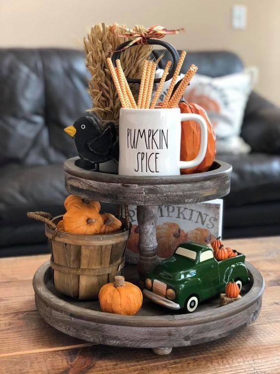 a wooden stand with wheat, fake pumpkins, a pretty mug and some colorful figurines